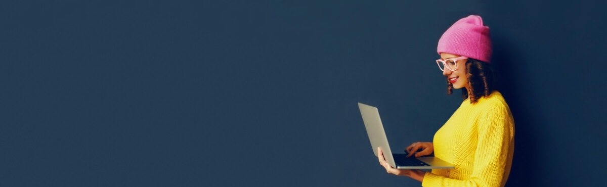 Woman holding laptop and smiling, representing the importance of working with development teams for great CX.